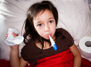 Girl sick in bed with thermometer 