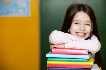 Smiling girl Leaning on Stack of Books